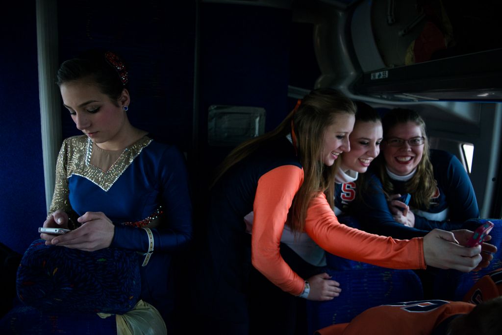 Meghan Sinisi, left, checks her phone as Natasha Olejar, Connorlynn Gaffney and Meghan Durling take a selfie at the back of their bus on the way to MetLife Stadium on Sunday afternoon. SUMB spent a majority of their day on buses, transporting from one stop to another on their way to MetLife Stadium.