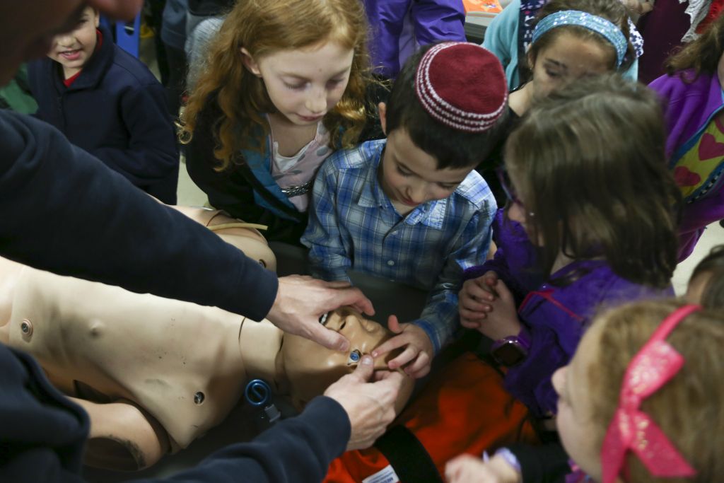 During a field trip, Isaac Bloom plays with a dummy at the Dewitt Fire Station that firefighters use to teach CPR.