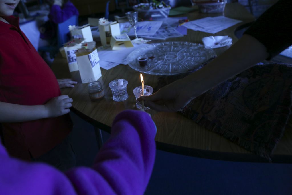 Second graders Jacob Fellman and Sydney Kanter close out the week by leading a prayer over the candles in a class Shabbat service on October 14, 2016.
