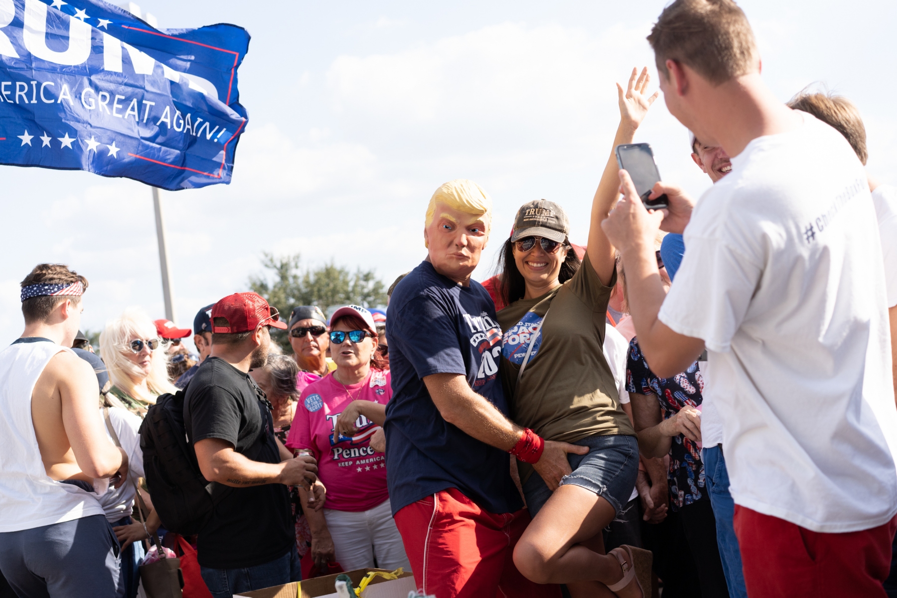 While waiting in line to enter President Trump's rally, Lee Stein grabs his significant other, Ashley Stein while a nearby supporter snaps a photo of them on October 31, 2018, at Estero, Fla