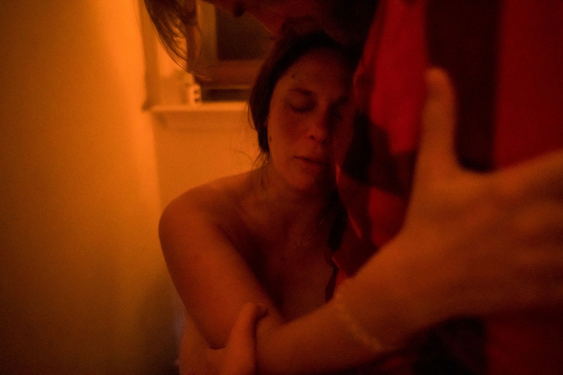 10:05pm: Just after getting out of the birthing pool, Kate labors while sitting on the toilet in her bathroom.