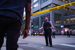 A Minneapolis police officer speaks to a bystander as police cordon off the area of Nicollet Mall near the shooting on August 26, 2020.
